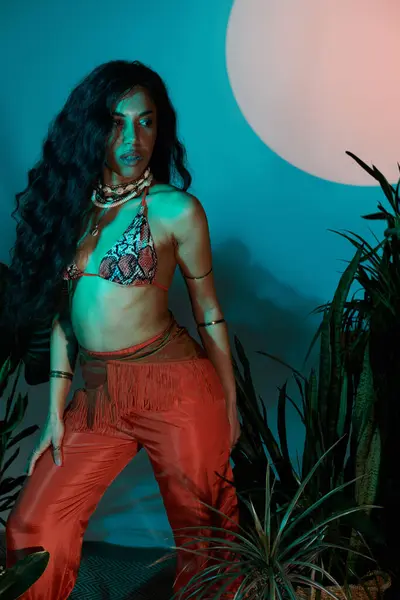 A beautiful young woman showcases her summer fashion in a colorful tropical setting during sunset. — Stock Photo