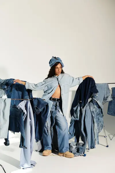 In a trendy summer scene, a young woman playfully flaunts her denim fashion sense. — Stock Photo