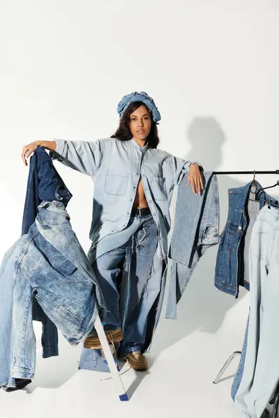 A confident young woman models diverse denim outfits in a bright, seasonal setting. — Stock Photo