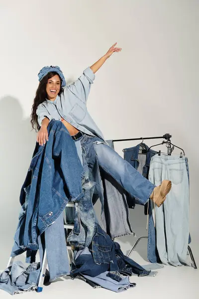 A cheerful young woman showcases a variety of trendy denim outfits in a vibrant summer setting. — Stock Photo