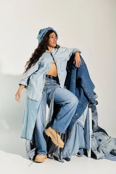 Una hermosa joven posa con confianza con capas de denim, encarnando la moda y las tendencias veraniegas. - foto de stock