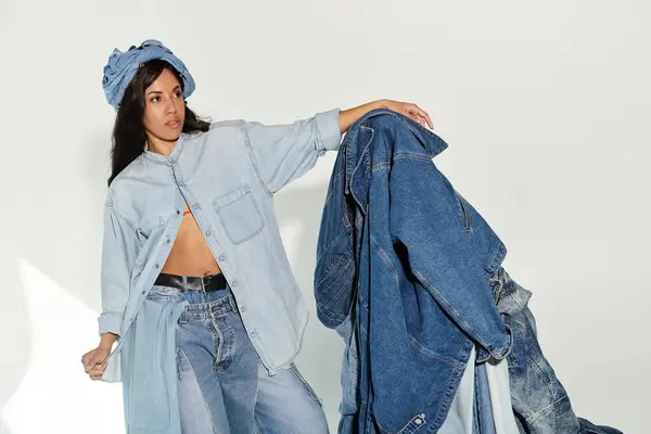 Charming young woman effortlessly poses in trendy denim outfit, emphasizing summer fashion vibes. — Stock Photo