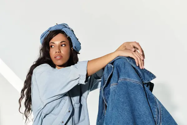 Eine schöne Frau prahlt mit ihrem Sommerstil in Jeans und schicker Kopfbedeckung und strahlt Selbstbewusstsein aus. — Stockfoto