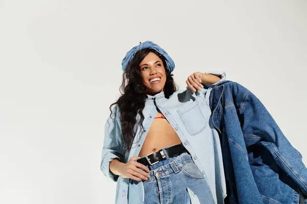Bright and stylish atmosphere showcases a beautiful woman wearing trendy denim attire and smiling. — Stock Photo