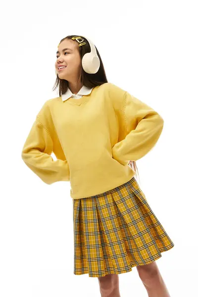 The young asian girl showcases her stylish school uniform with flair while smiling in a bright studio. — Stock Photo