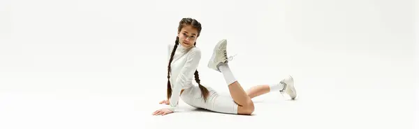 Girl in trendy sportswear poses creatively on studio floor, showcasing her fitness and style, banner — Stock Photo