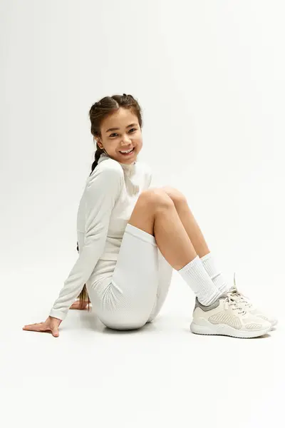 Una ragazza asiatica in forma brilla in abbigliamento sportivo elegante, irradiando gioia ed energia in studio impostazione. — Foto stock