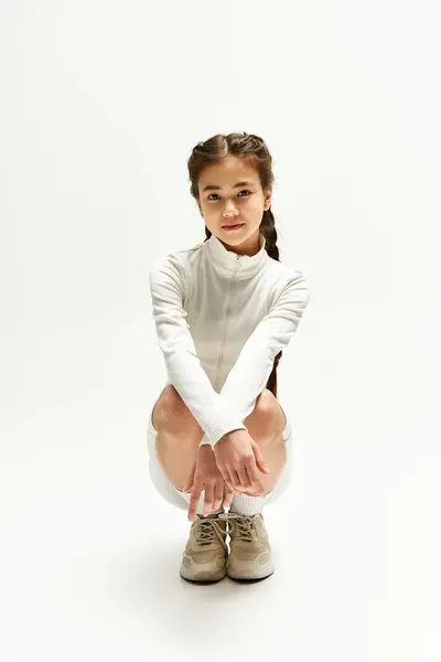 Stylish asian girl showcases her athletic wear while posing gracefully in a modern studio. — Stock Photo