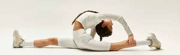 A fit asian girl showcases her athleticism by stretching in a contemporary studio, banner — Stock Photo