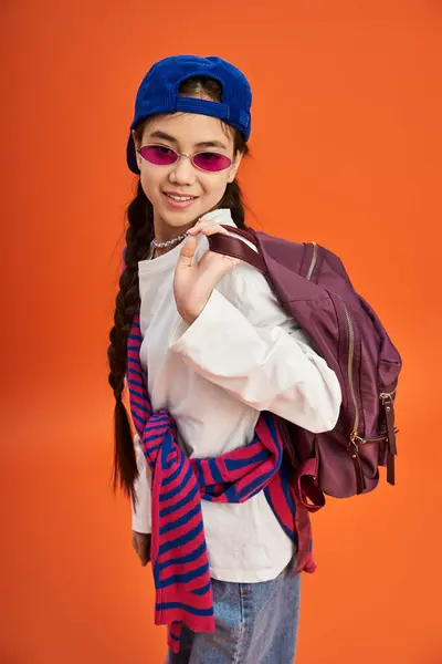 Teen girl showcases her stylish outfit with a playful expression in a bright studio setting. — Stock Photo
