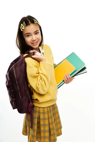 Una studentessa asiatica allegra mostra il suo stile alla moda mentre tiene i quaderni. — Foto stock