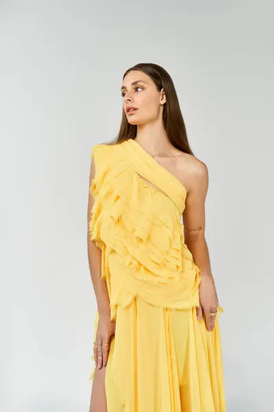 A lovely woman poses gracefully in a chic yellow dress, showcasing summer style and elegance. — Stock Photo