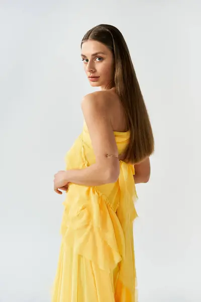 A young woman radiates beauty in a flowing yellow dress, embodying summers warm spirit. — Stock Photo