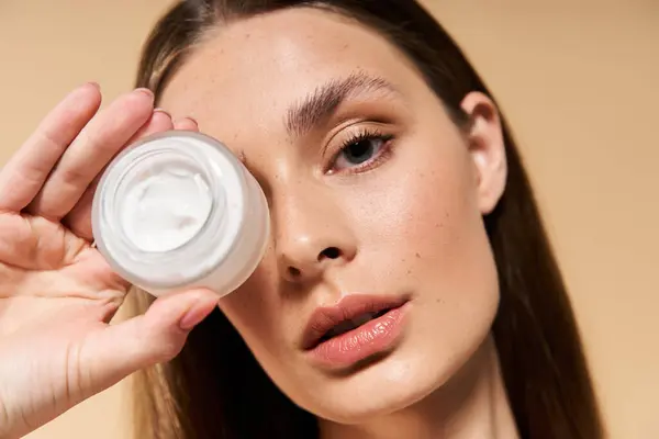 Jovem mulher destaca seu produto de cuidados com a pele enquanto abraça o brilho e a beleza do verão. — Fotografia de Stock