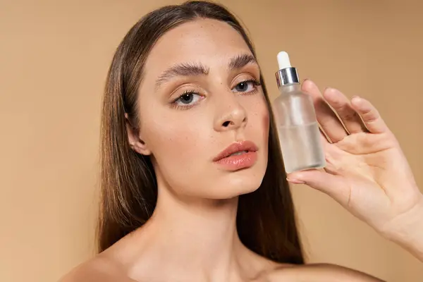 Jeune femme souligne l'élégance de l'été avec un teint éclatant et un produit de soins de la peau. — Photo de stock