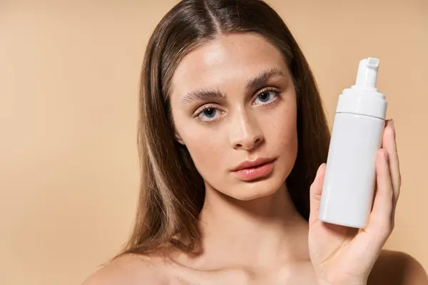 A young woman showcases a skincare product while embracing the warmth of summer elegance. — Stock Photo