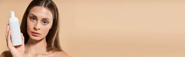 Young woman showcases a skincare product, radiating summer style and confidence. — Stock Photo