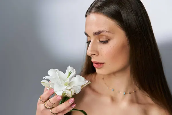A young woman shares a serene moment with a radiant white flower, ideal for summer. — Stock Photo