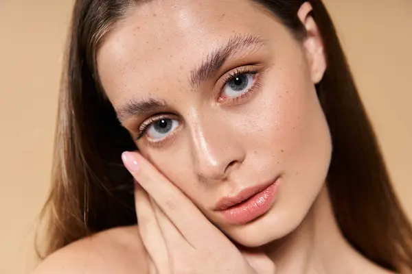 A beautiful young woman with striking features gently touches her face, embodying summers charm. — Stock Photo