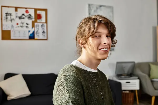 Молодий чоловік зручно сидить вдома, зосереджений на навчанні та оточений художнім натхненням. — стокове фото