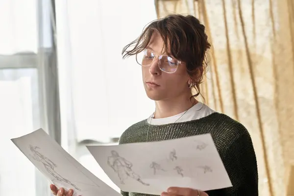 Man studies his sketches closely, immersing himself in the artistic process at home. — Stock Photo