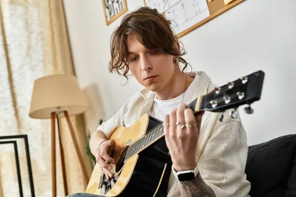 Uomo impegnato a suonare la chitarra a casa, mettendo in evidenza un momento di espressione artistica. — Foto stock