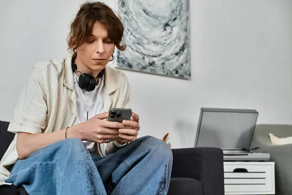 Homem usa seu smartphone em uma acolhedora sala de estar cheia de materiais de estudo. — Fotografia de Stock