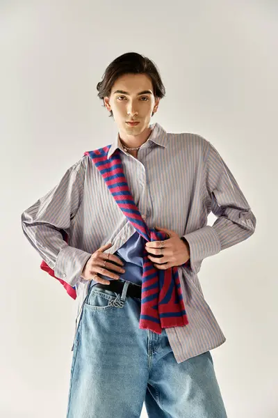 A young non binary person displays stylish attire and confident presence in a modern setting. — Stock Photo