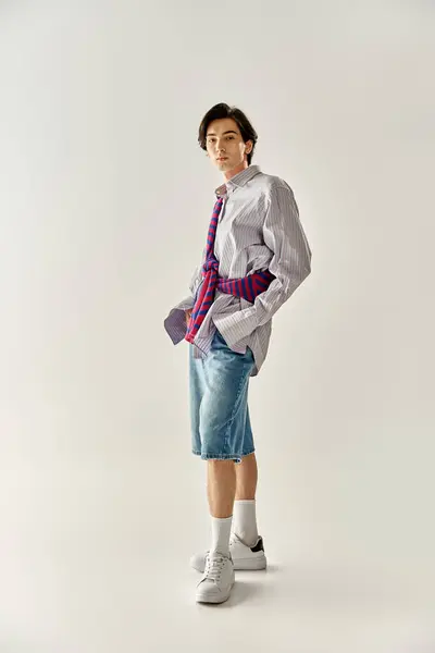 A confident young non binary individual stands in a trendy outfit, embodying modern fashion. — Stock Photo