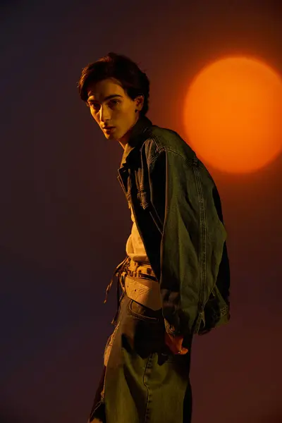 A young fashionable non binary person stands confidently during sunset, showcasing unique style. — Stock Photo