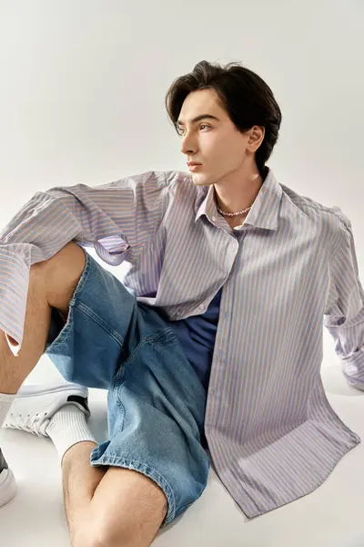 Jeune personne élégante posant avec confiance en tenue moderne, mettant en valeur divers sens de la mode. — Photo de stock