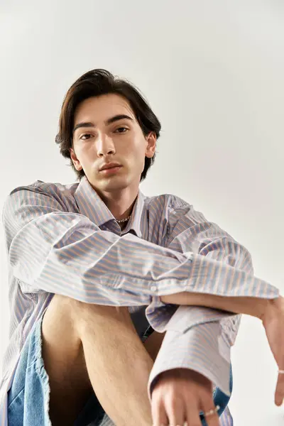 A non binary person showcases their unique style with casual confidence in a modern setting. — Stock Photo
