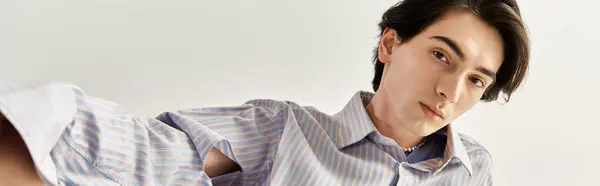 A stylish non-binary person confidently showcases vibrant fashion in a minimalist setting, banner — Stock Photo