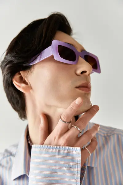 A stylish non binary person showcases fashionable sunglasses and rings, embodying LGBTQ pride. — Stock Photo