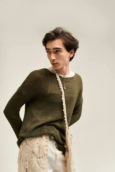 Non binary individual showcases unique fashion in a minimalist studio, reflecting personal identity. — Stock Photo