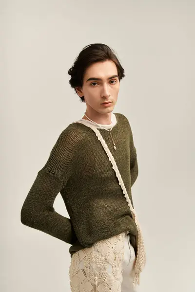 Stylish non binary individual showcases unique fashion in a serene studio ambiance. — Stock Photo