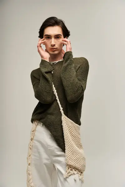 Una giovane persona alla moda non binaria posa con fiducia, vestita con abiti alla moda. — Foto stock