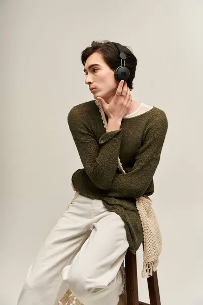 A stylish non-binary individual models fashion with confidence while listening to music. — Stock Photo