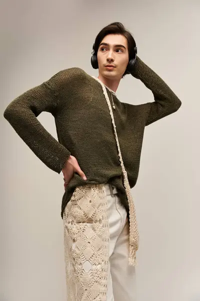 A young, fashionable non binary individual poses confidently, showcasing unique style and identity. — Stock Photo