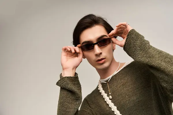 A stylish young non-binary person showcases a creative fashion sense with confidence and poise. — Stock Photo