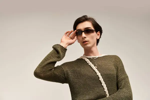 A young non-binary person poses confidently in trendy sunglasses and casual wear. — Stock Photo