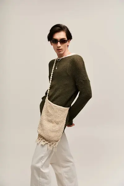 A stylish non binary person stands confidently, showcasing unique fashion in a studio. — Stock Photo
