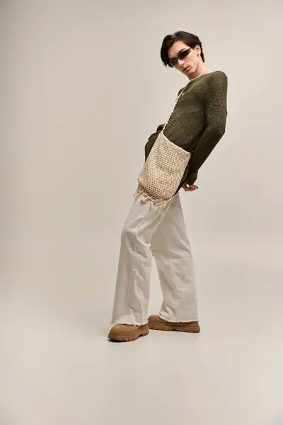 A young non binary person displays their unique fashion sense with confidence in a studio. — Stock Photo