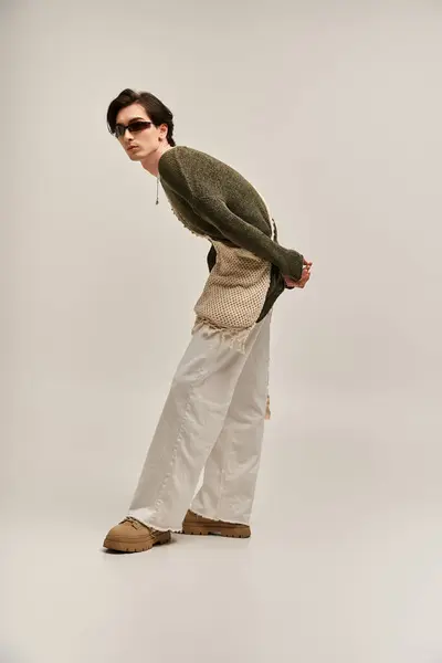 A young fashionable person presents their unique style in a minimalist studio setting. — Stock Photo