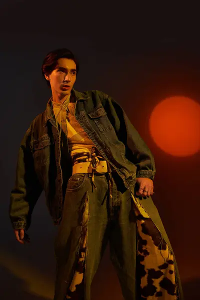 Una giovane persona non binaria mette in mostra la moda unica in uno sfondo tramonto vibrante. — Foto stock