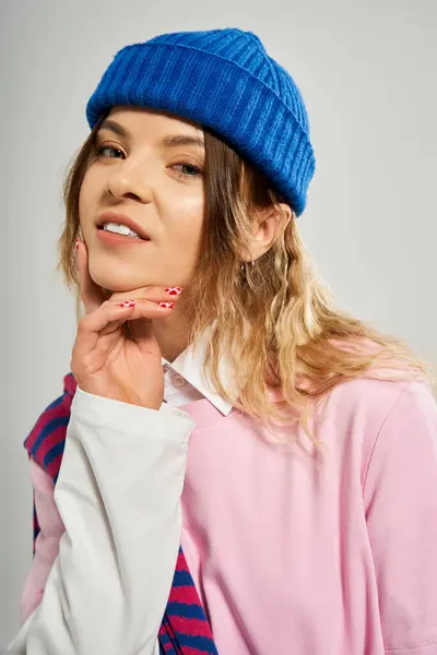 Una mujer bastante joven muestra su atuendo de moda mientras posa en un ambiente de estudio. - foto de stock