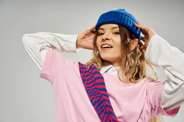 Una joven elegante posa con confianza, destacando su sentido de la moda en un estudio de moda. - foto de stock