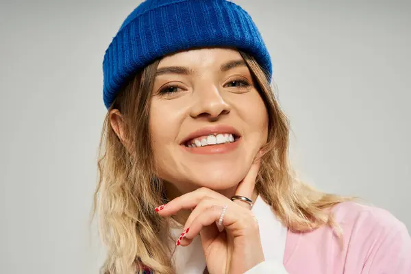 A young woman shines with joy in a vibrant stylish ensemble while wearing a beanie. — Stock Photo