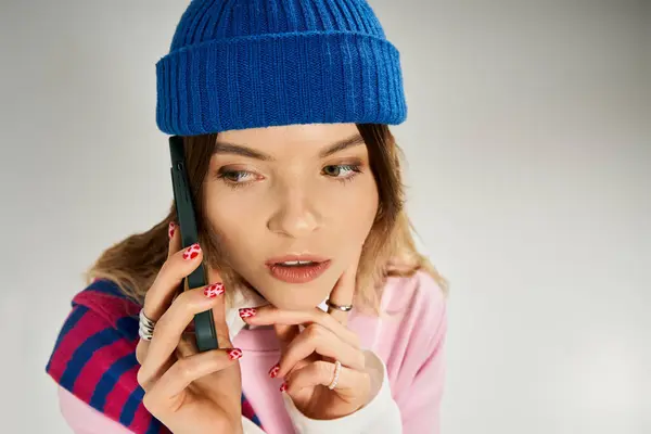 A pretty young woman in a stylish outfit is engaged in a phone conversation in a modern studio. — Stock Photo