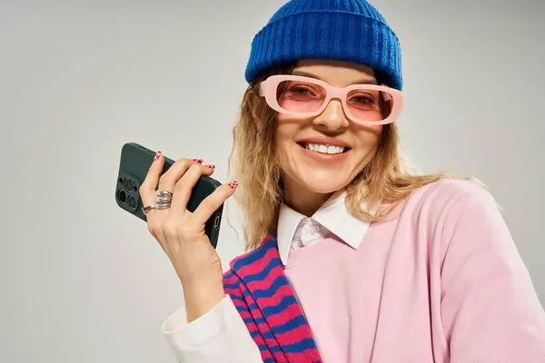 A pretty young woman dressed in a stylish outfit exudes confidence in a studio. — Stock Photo